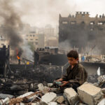 युद्ध के बाद खंडहर बने शहर में मलबे के बीच बैठा एक बच्चा, आसपास तबाही का दृश्य